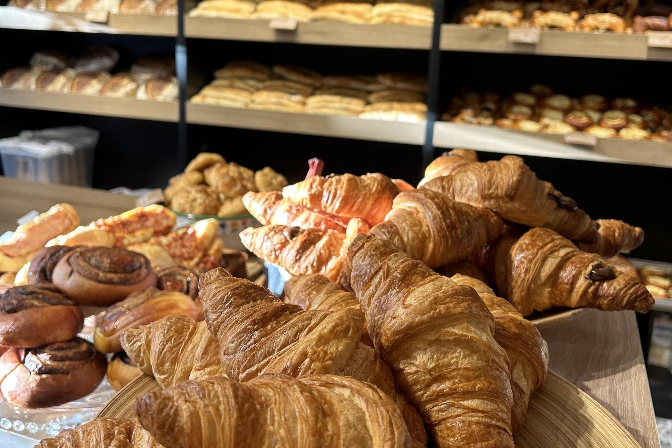 Čerstvě upečené croissanty, plundry a sladké pečivo na pultu pekárny